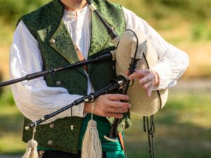 Man in green vest playing the bagpipes