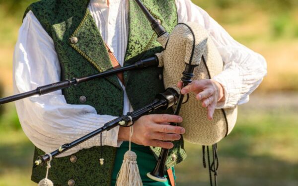 Man in green vest playing the bagpipes