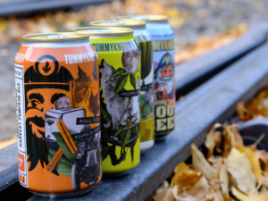 Cans of beer on rail with fall leaves