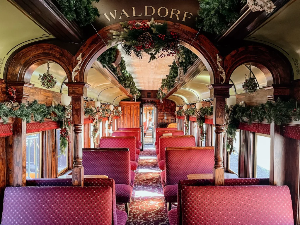 Georgetown Loop Waldorf car interior showcasing elegant arched woodwork and holiday decorations