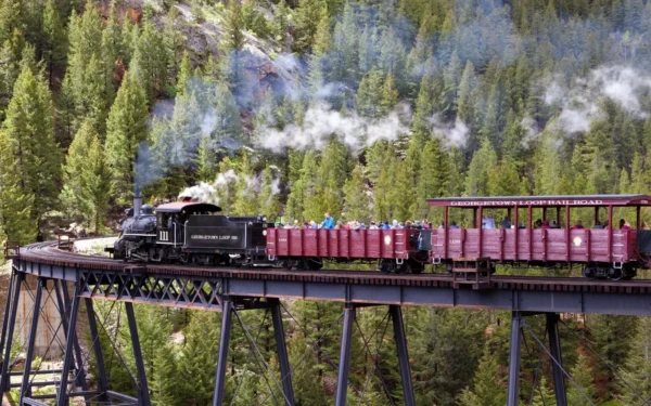 Georgetown Loop steam locomotive crossing Devil's Gate High Bridge with passengers in open-air cars