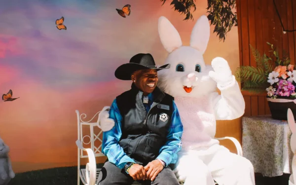 Smiling guest in a cowboy hat posing with the Easter Bunny mascot at the Georgetown Loop Bunny