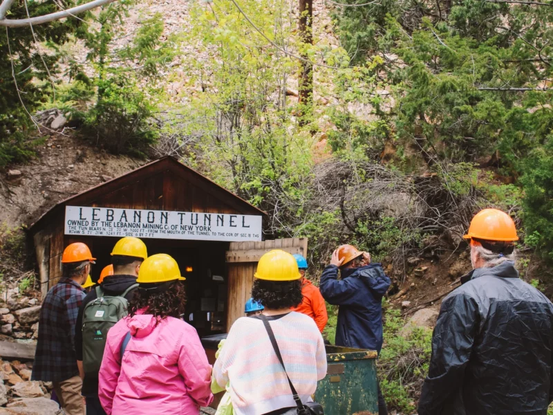Visitors wearing safety helmets preparing to enter Lebanon Mine tunnel on Georgetown Loop Railroad