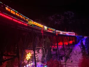 Georgetown Loop Winter Holiday Train with festive lights crossing Devil's Gate High Bridge at night