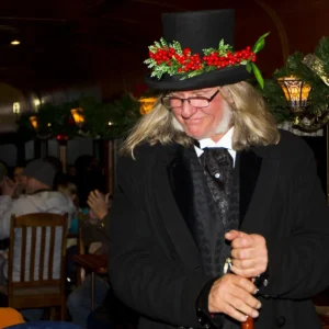 Victorian costumed entertainer with holly-decorated top hat performing aboard Georgetown Loop