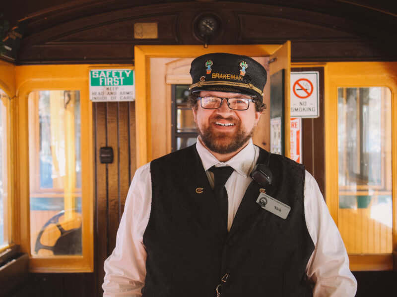 Man standing on train car, smiling
