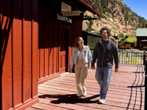 couple walking by train depot holding hands