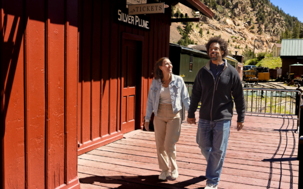 couple walking by train depot holding hands