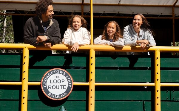 Family leaning over side of train car